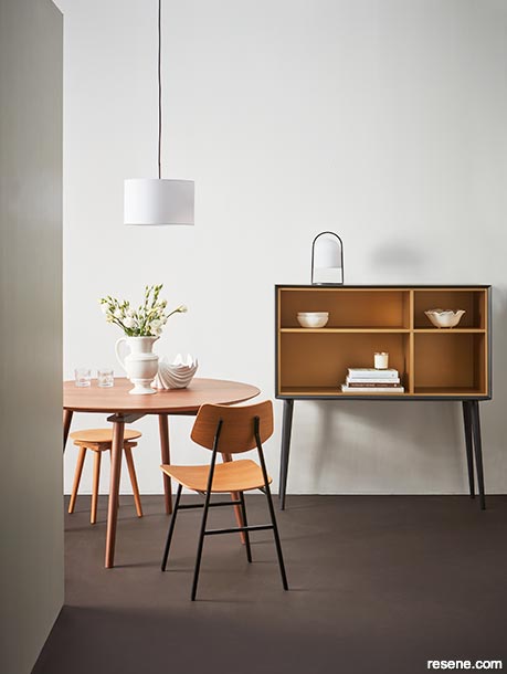 A contemporary minimalist dining room using dark hues